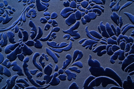 A shimmering velvet jacquard fabric texture background in deep royal blue. The intricate, embossed floral designs add a touch of luxury and depth, ideal for opulent home furnishings and evening gowns.の素材