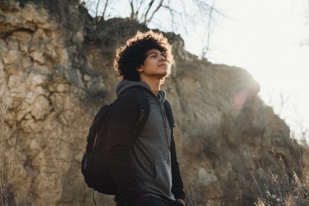 A young Hispanic man practicing mindfulness while walking in nature, appreciating the present moment.の素材