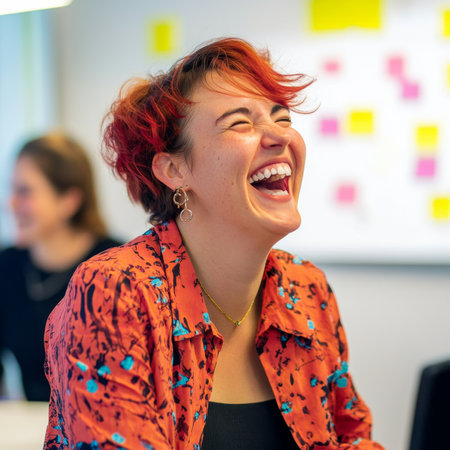 Young adult Caucasian businesswoman laughing with coworkers during a creative brainstorming session, vibrant and open office with whiteboards and post-itsの素材