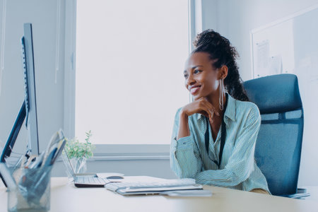 A mature African-American woman hosts a virtual leadership training session from her bright office, using digital breakout rooms and live polling tools to keep participants engaged and motivatedの素材