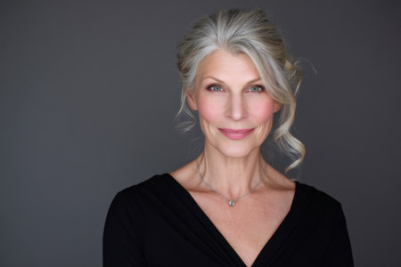 A mature Caucasian businesswoman plans a professional headshot event for staff, coordinating lighting, photographer schedule, and makeup touch-ups to help everyone look their bestの素材
