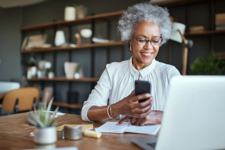 Mature Black woman organizing executive coaching sessions, scheduling experts for one-on-one virtual developmentの素材