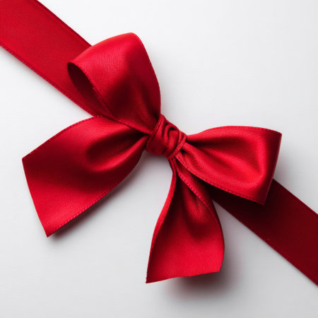 Red satin ribbon bow on white background. Flat lay, top view.の素材