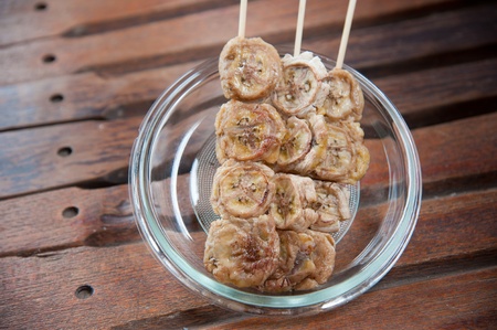 Delicious Thailand dessert and snack, baked whole banana on stick and syrup toppingの写真素材