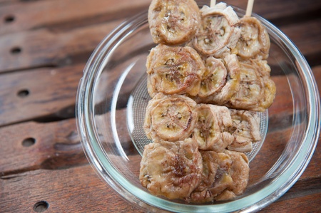Delicious Thailand dessert and snack, baked whole banana on stick and syrup toppingの写真素材