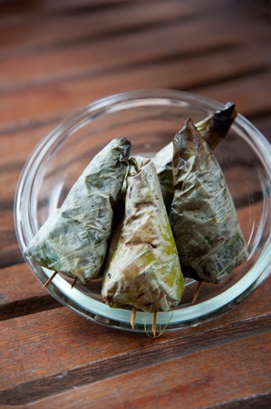 Delicious Thailand dessert, sticky rice toast with taro and banana leaf on wood backgroundの写真素材