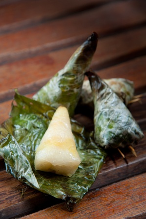 Delicious Thailand dessert, sticky rice toast with taro and banana leaf on wood backgroundの写真素材