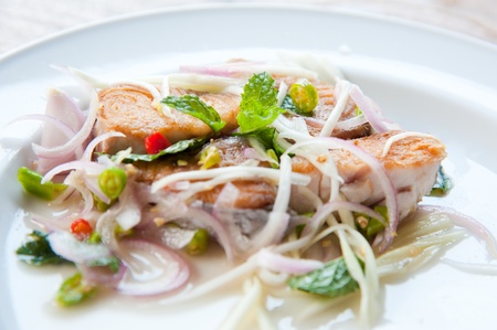 Spicy salad with fried fish and green herb in Thai styleの写真素材