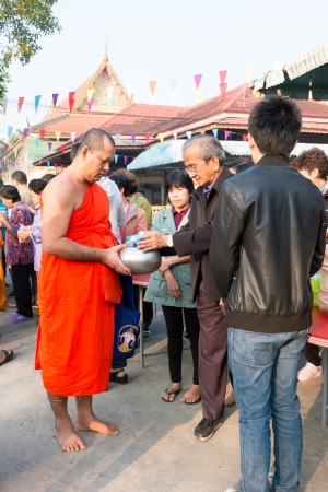 Nonthaburi, THAILAND - Jan 1, 2014    Unidentified Buddhist monks are given food offering from people in the morning for New Year Day  on January 31, 2014 in Sak Yai Temple, Nonthaburi  Thailand のeditorial素材