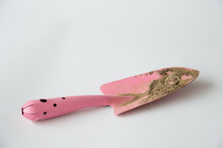 Dirty small pink shovel on white backgrundの写真素材