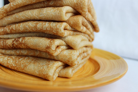 Pancakes with butter on a plate, as a symbol of ancient Slavic celebration of Carnival. Meet spring, winter farewell.の写真素材