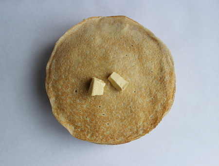 Pancakes with butter on a plate, as a symbol of ancient Slavic celebration of Carnival. Meet spring, winter farewell.の写真素材