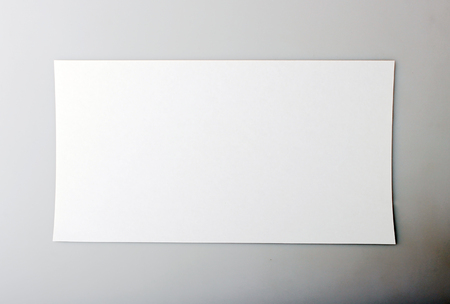 horizontal single white sheet of paper on a gray backgroundの写真素材