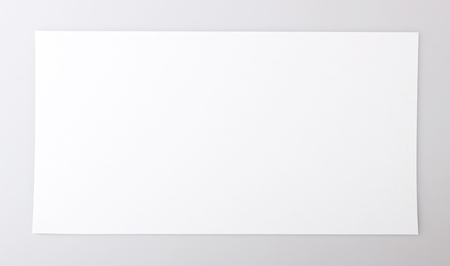 horizontal single white sheet of paper on a gray backgroundの写真素材