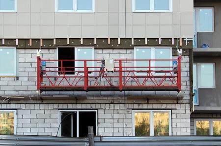 construction suspended cradle without workers on a newly built high-rise buildingの写真素材