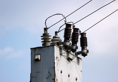 electrical wires extending from the transformer station near the railway on a background of blue skyの写真素材