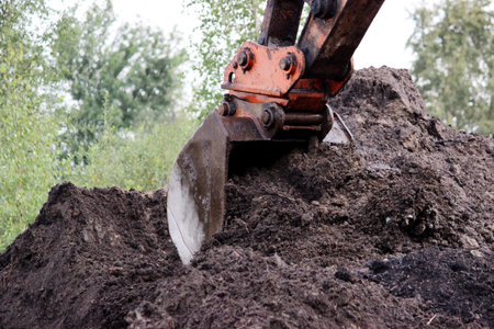 the dirty work of the excavator bucket, which digs and leveled the ground and scoops water on road...