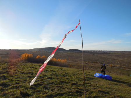 wind cone and paraglider on a slope. West wind on the mountain Mozhayskaya, Leningrad region, Russiaの写真素材
