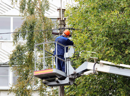 Electrical worker repairing the wires on the pole with the help of the lift car