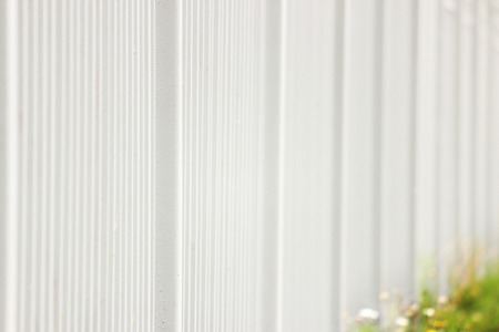 white metal fence in the long run as a background and green leaf.の写真素材