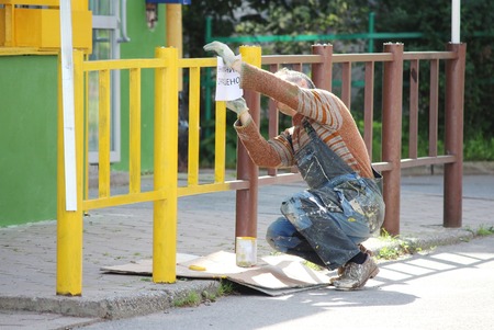 painter hangs on the fence painted sign warning: attention to paintの写真素材