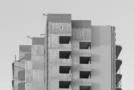 black and white photo windows in a newly built house against a cloudless blue skyの写真素材