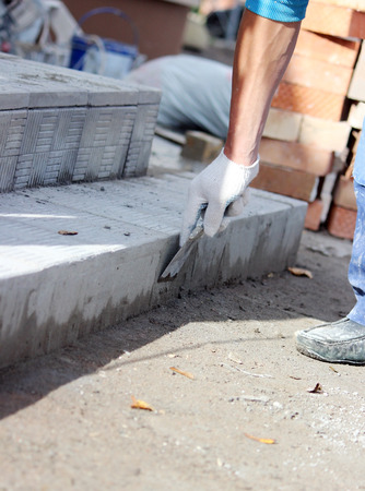 tiler processes the surface for laying the stone tiles on the steps in the repair of the office buildingの写真素材