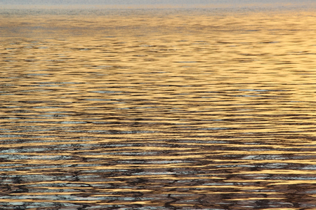 water in the river of golden rays of the setting sun in the background. gold on blueの写真素材