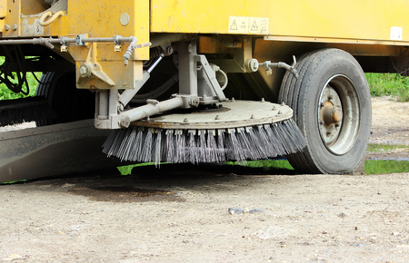 Orange round brush working on sweeper urban carの写真素材