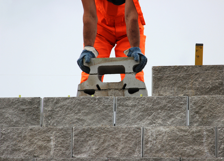 Bricklayer putting down another row of bricks in site during the construction of the viaductの写真素材