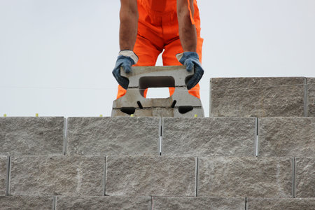 Bricklayer putting down another row of bricks in site during the construction of the viaduct