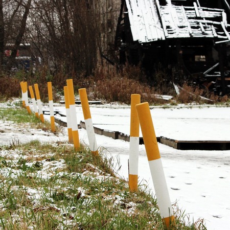 sidewalk near the house and white yellow parking pole stationary strengthened against the entry of vehicles. Relevant when the danger of terrorist attacks.の写真素材