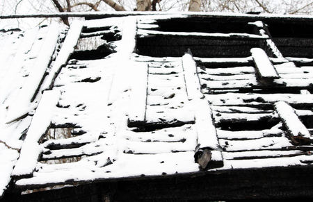 Black and white photo snowy abandoned burned-out fire wooden black houseの写真素材