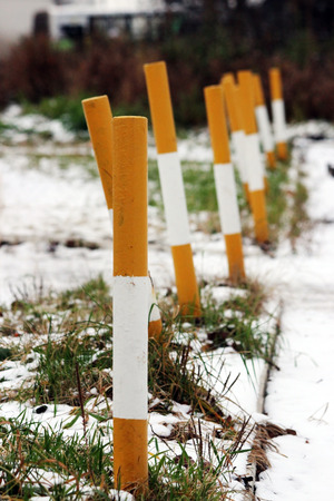 sidewalk near the house and white yellow parking pole stationary strengthened against the entry of vehicles. Relevant when the danger of terrorist attacks.の写真素材