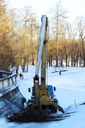 lift by which workers cut branches of trees lime trees in the park in winterの写真素材