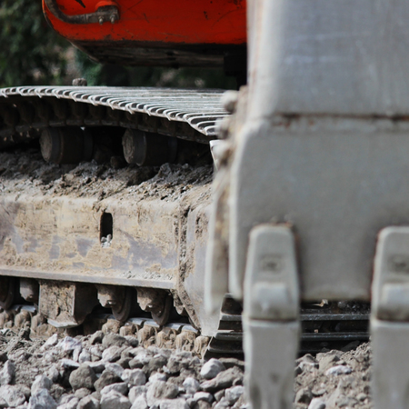 Excavator bucket digging a trench at the side of the road for its expansionの写真素材