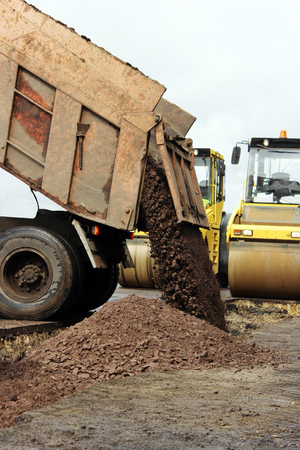Construction truck unloads ground to the construction site and road widening.の写真素材