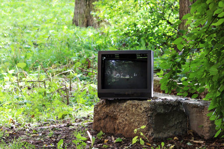old broken television stands on a concrete pedestal in the city yardの写真素材