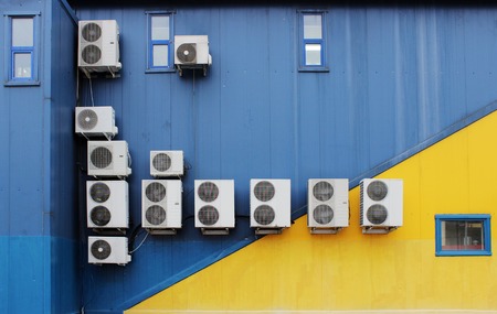 several outer industrial air conditioners are cooling the air in a large shopping center in the summerの写真素材