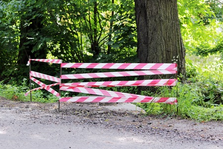 red white warning tape fencing is protects the open hatchの写真素材