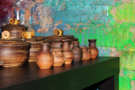 many small clay jugs and pots standing on a green table