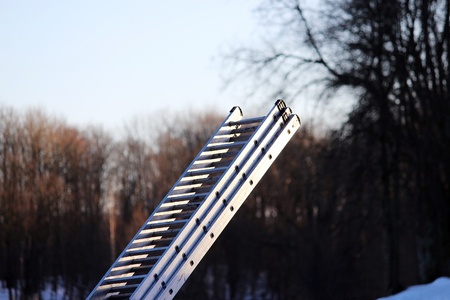 foldaway metal ladder in the park in the winter for work at heightの写真素材