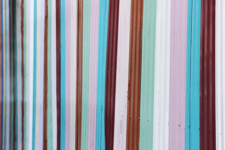 metal fence, painted with stripes and paint in different colorsの写真素材