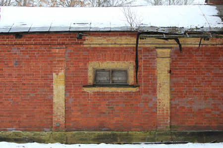 texture of the brick wall of the old historical building with a small window to winterの写真素材