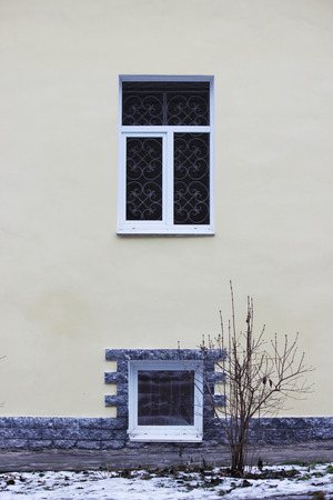 beige outer wall of the house, two windows and transformer cabinetの写真素材