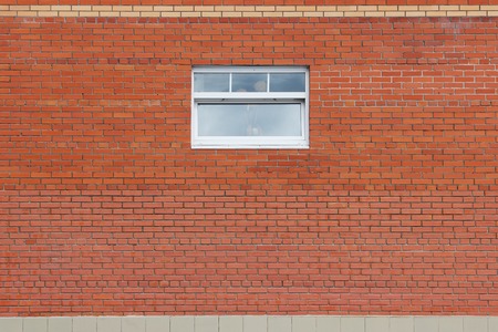 Brick wall and one window in a background image.の写真素材