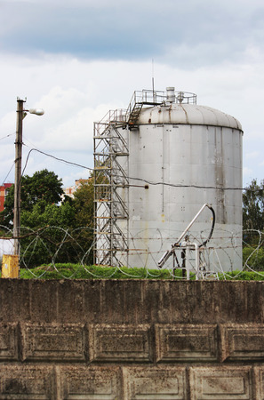 metal tower with flammable fuel in the territory of a fence with barbed wireの写真素材