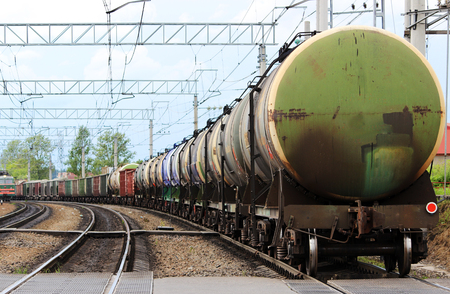 a lot of colored cars on a freight train, which travels along the rails of the railway.の写真素材