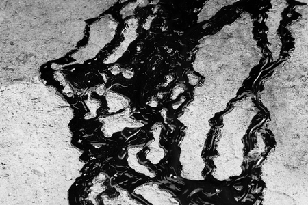 tracks of black tar are poured on the sand.の写真素材