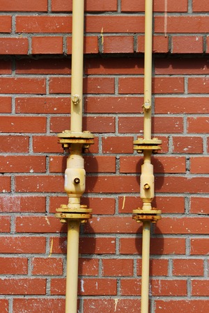 Gas pipe on the wall on the wall of a brick houseの写真素材
